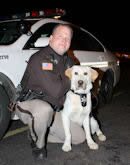 Deputy Killey and Gunner pose in front of their squad car